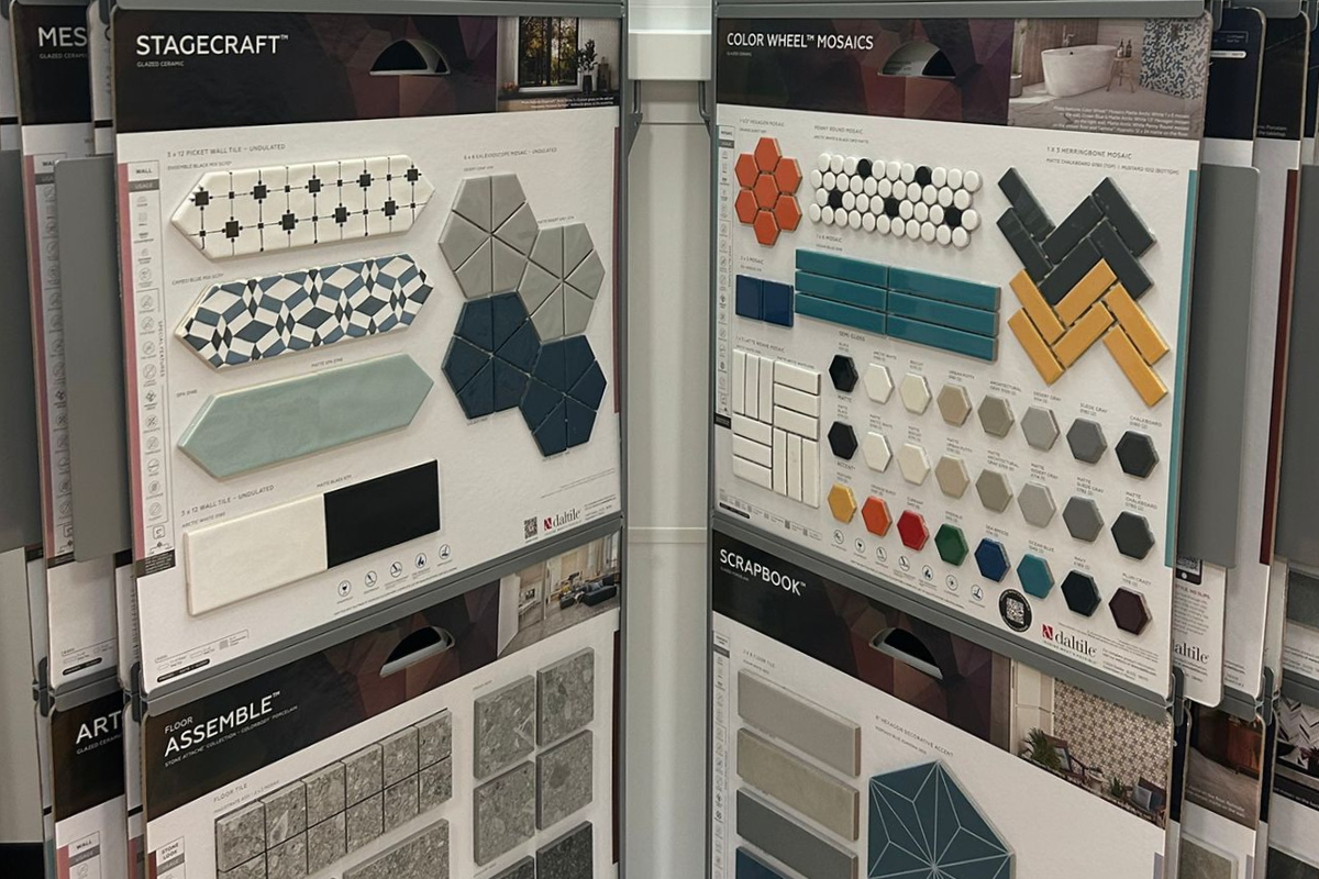 Display boards with various tile samples including geometric patterns, hexagons, and rectangular tiles in different colors and finishes.